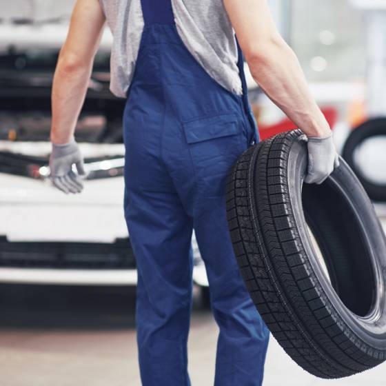 mechanic-holding-tire-tire-repair-garage-replacement-winter-summer-tires